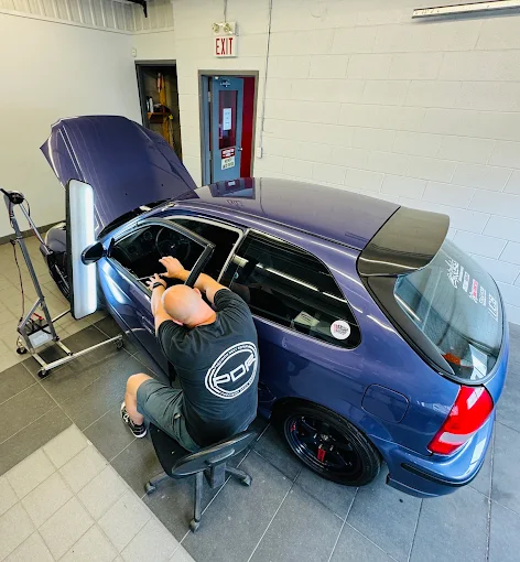 Paintless dent repair technician working a dent for a Oakville customer